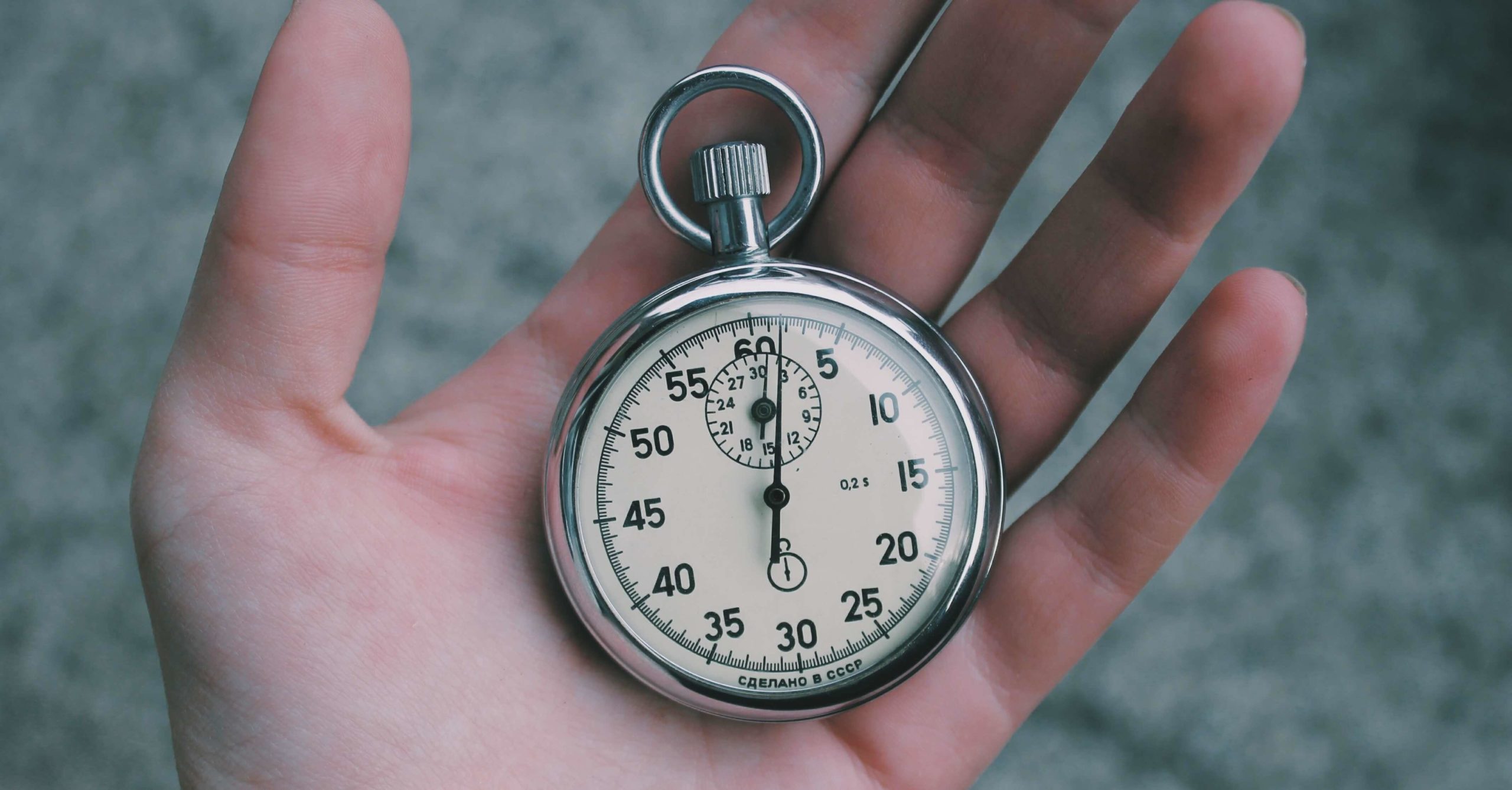 Hand with old fashioned stopwatch timer