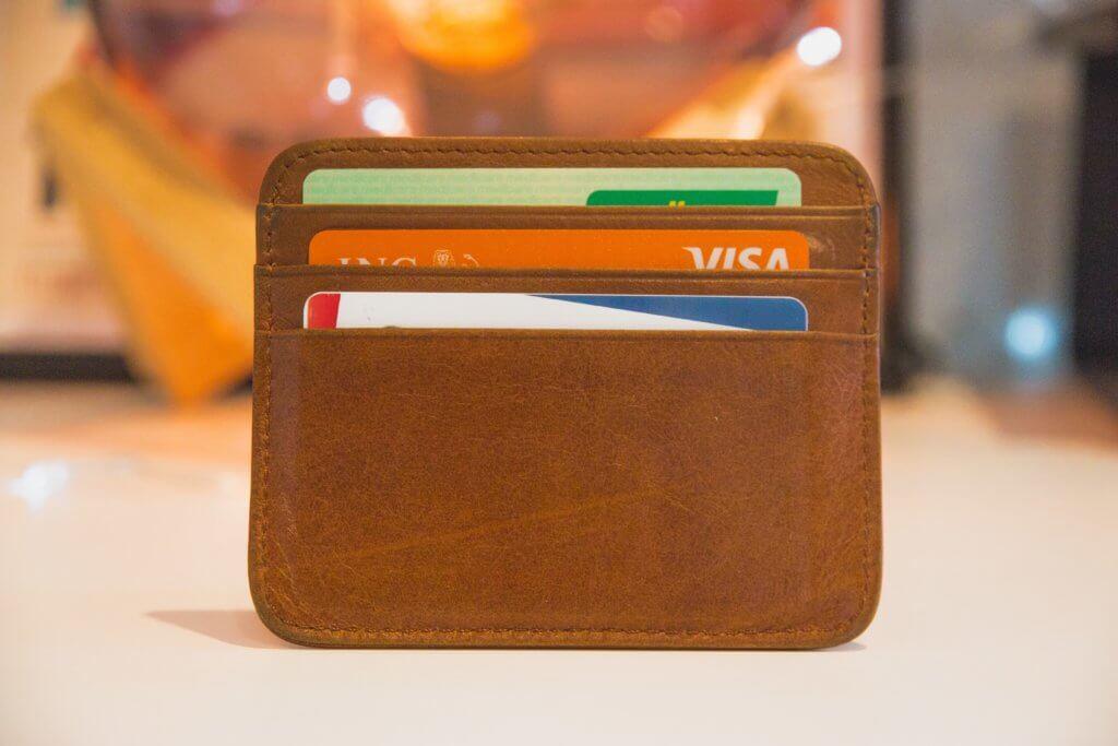 Brown leather mini wallet with three credit cards pertruding