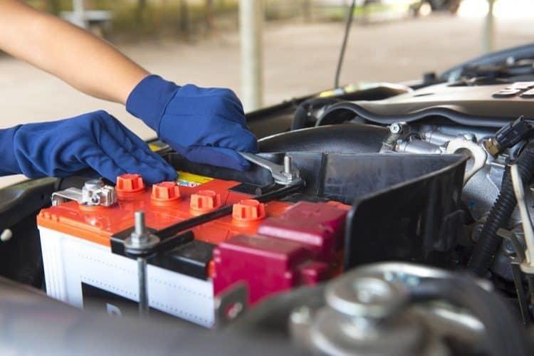 Car battery being installed by a gloved technician